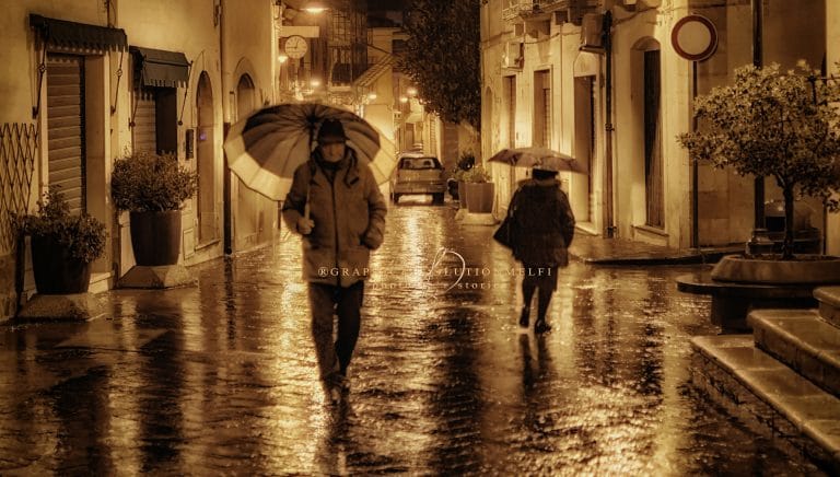 Passanti | Melfi sotto la pioggia in Via Ronca Battista
